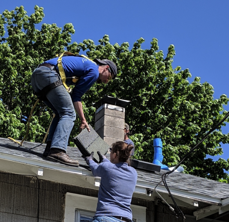 Two volunteers working on a roof